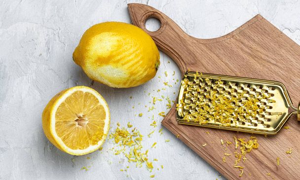 Sarı organik limon, lezzet ve özel alet. Açık arkaplanda rende rende kabuğu ve limon tadı, uzun afiş biçimi. en üstteki görünüm. - Fotoğraf, Görsel