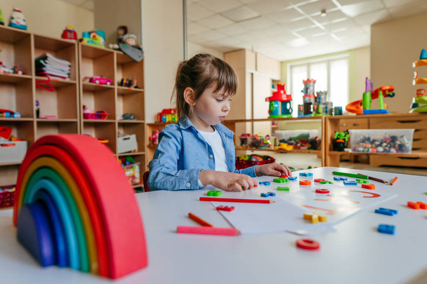 Little girl playing with colorful plastic letters at kindergarten or primary school. Tactile and sensory methods for learning. Education concept. - Φωτογραφία, εικόνα