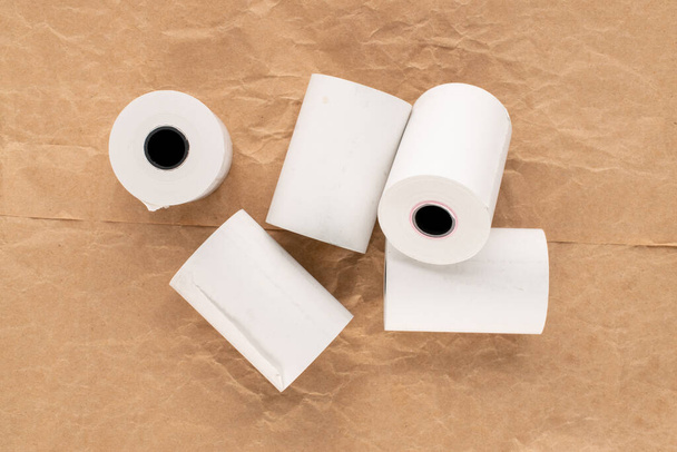 Несколько рулонов бумажной ленты для кассового аппарата на бумаге, макро, вид сверху. - Фото, изображение