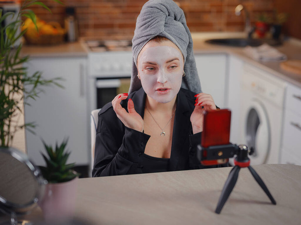 Famous blogger. Cheerful female vlogger showing beauty mask while recording video and giving tips for her beauty blog. Woman testing new product. cosmetic face mask - Zdjęcie, obraz