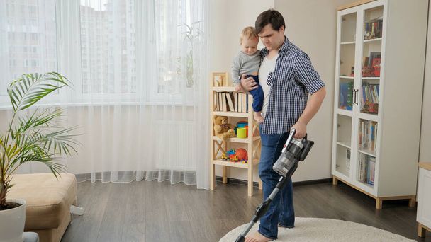 Young single father doing housework and cleanup with his little baby son - Foto, Imagem