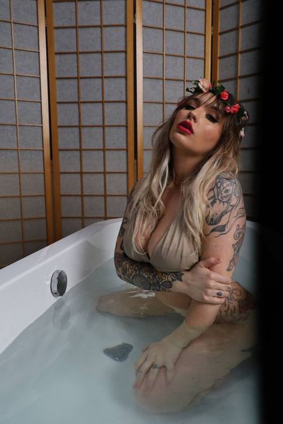 Photo of a beautiful white model sitting in a tub - Foto, afbeelding