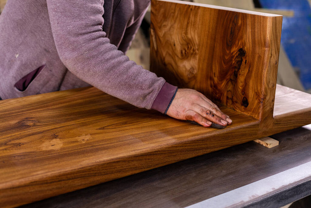 Closeup de carpinteiro que reveste uma mesa de madeira com óleo de linhaça protetor. Processo de fazer uma mesa de madeira - Foto, Imagem