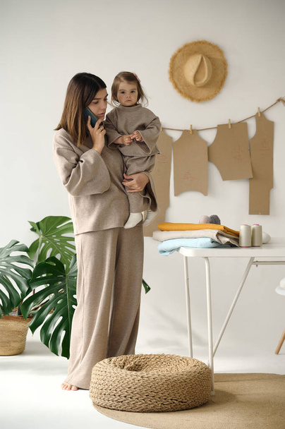 Dressmaker making clothes in her studio with her daughter. - Φωτογραφία, εικόνα