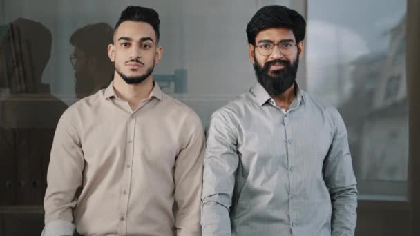Happy homens confiantes jovens colegas profissionais parceiros árabes empresários hispânicos olhando para a câmera mostrando polegares para cima gesto sinal mão recomendando melhor escolha feedback positivo - Filmagem, Vídeo