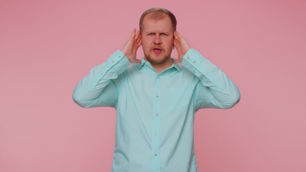 Frustrato uomo irritato coprendo le orecchie, evitando consigli ignorando voci rumorose sgradevoli rumore - Filmati, video