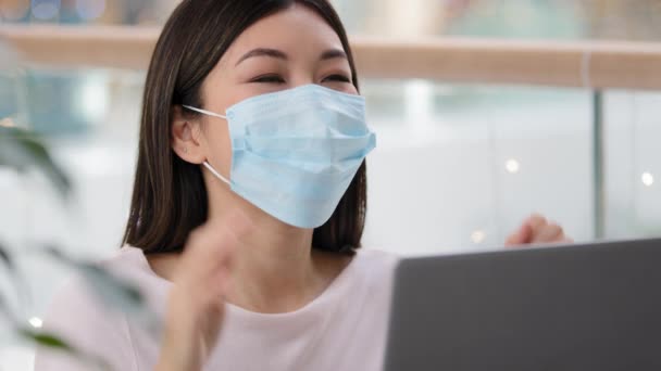 Portrait asian successful girl in medical protective mask business woman looking laptop receives notification recovery from covid wins job offer achievement goal online betting celebrate luck victory - 映像、動画