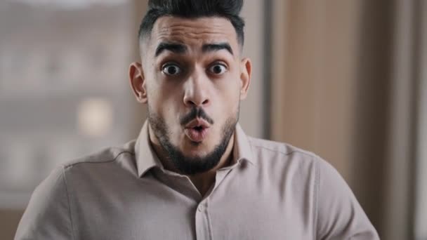 Close up shocked happy young hispanic male business man professional worker surprised looking at camera make big eyes rejoice victory amazed guy winner demonstrate wow reaction joyful face expression - Metraje, vídeo
