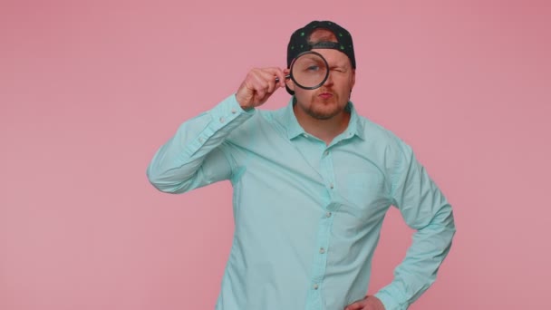Onderzoeker onderzoeker onderzoeker met vergrootglas in de buurt van gezicht, op zoek naar camera met grote zoom oog - Video