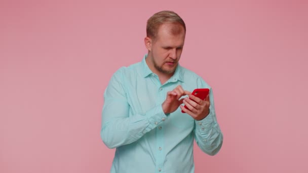 Šťastný vzrušený muž použít mobilní telefon říct wow ano zjistil velkou výhru zprávy dělá vítězný gesto - Záběry, video