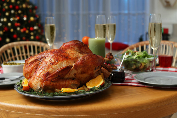 Festive dinner with delicious baked turkey and sparkling wine on table indoors. Christmas celebration - Photo, image