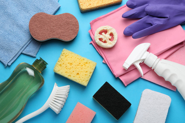 Πολλά διαφορετικά σφουγγάρια και άλλα προϊόντα καθαρισμού σε γαλάζιο φόντο, επίπεδη lay - Φωτογραφία, εικόνα