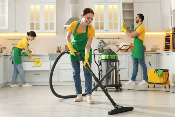 Team of professional janitors working in kitchen - Φωτογραφία, εικόνα