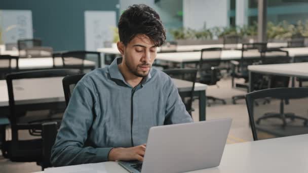 Kimerült stresszes arab fiatal üzletember alkalmazott srác elterelt laptop szünet közeli irritált szemek enyhíti a fájdalmas kényelmetlenséget túlhajszolt munkavállaló úgy érzi, fejfájás fáradtság után irodai munka - Felvétel, videó