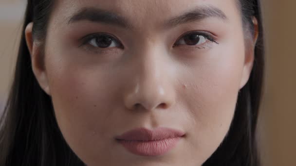 Extreme close up Asian woman face portrait body part perfect clean young skin after beauty treatment natural makeup wide eyebrows friendly expression Korean woman lady looking at camera good eyesight - Imágenes, Vídeo
