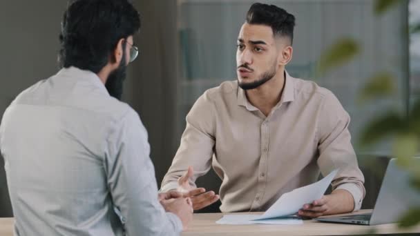 Hispanic young businessman man financial advisor agent lawyer worker consulting unknown male client customer explaining insurance contract benefits negotiating giving business advice at office meeting - Footage, Video