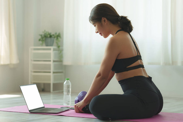 Mujer joven que practica yoga siga a profesor en la clase en línea del ordenador portátil en casa. Concepto de calma y relajación. - Foto, Imagen
