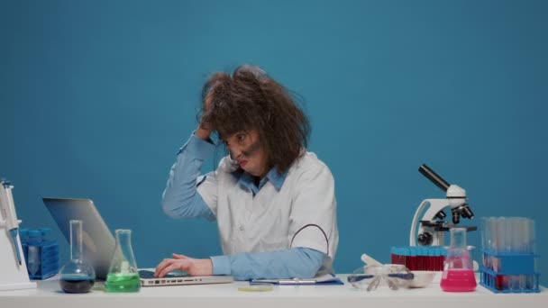 Zábavný šílený vědec pracující na notebooku a chovat se šíleně - Záběry, video