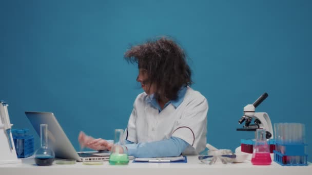 Безумная глупая химик работает с микроскопом в студии - Кадры, видео