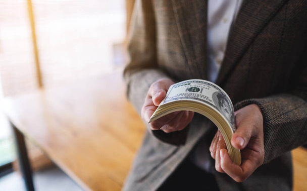 Para ve finansal konsept için Amerikan doları banknotları tutan ve sayan bir kadının yakın plan görüntüsü - Fotoğraf, Görsel