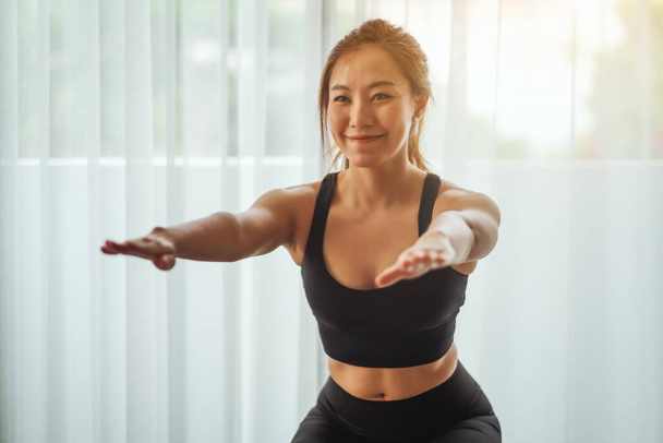 Closeup image of a beautiful young asian woman doing squats , workout at home - Photo, Image