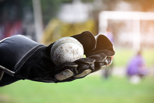 Oude lederen cricketballen voor training en training op zandbodem naast de baan, zachte en selectieve focus op rode cricketbal. - Foto, afbeelding