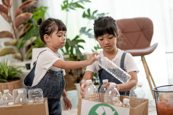 Aasialainen pieni tyttö on erillinen roskakoriin kierrättää - Valokuva, kuva