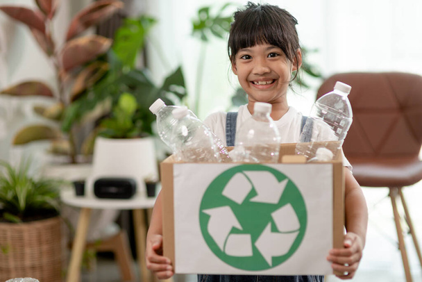 Ασιατικό κοριτσάκι είναι ξεχωριστό σκουπίδι για ανακύκλωση - Φωτογραφία, εικόνα
