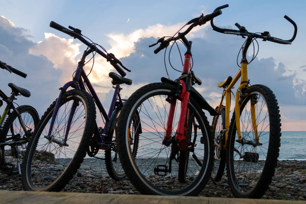 Ряд велосипедів на пляжі відчувають блакитне хмарне небо і морський фон
 - Фото, зображення