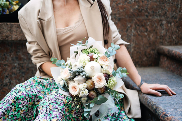 Flowers delivery. Faceless portrait of woman with receiving beautiful flowers bouquet from delivery outdoors - Foto, afbeelding