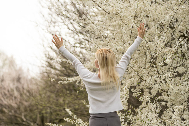 mooie jonge vrouw in de bloei cherry blossoms tuin. - Foto, afbeelding