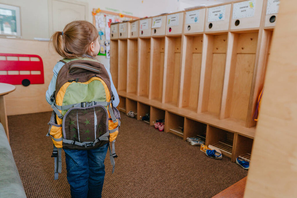 Erster Tag in der Schule oder im Kindergarten. Rückansicht eines kleinen Mädchens mit Rucksack, das in die Schule geht. Zurück zum Schulkonzept. - Foto, Bild