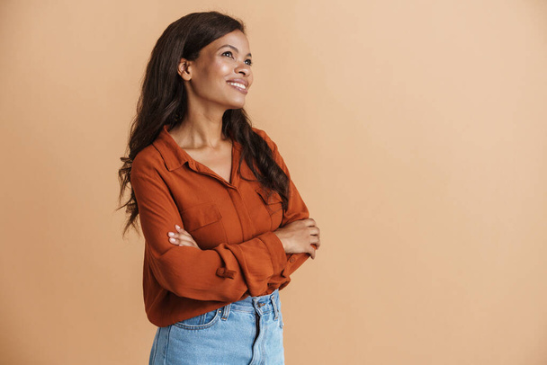 Young black woman wearing shirt laughing and looking upward isolated over beige background - Foto, afbeelding