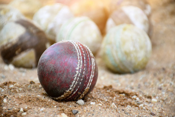 Old leather cricket balls for training and practising on sand floor beside the court, soft and selective focus on red cricket ball. - Фото, изображение