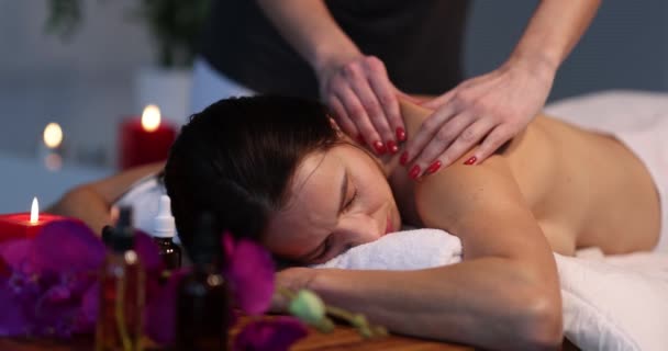Woman enjoys spa resort while lying on table treatment procedure next to candle - Metraje, vídeo