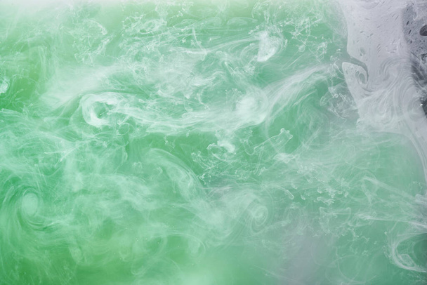 Green smoke on white ink background, colorful fog, abstract swirling emerald ocean sea, acrylic paint pigment underwater - Φωτογραφία, εικόνα