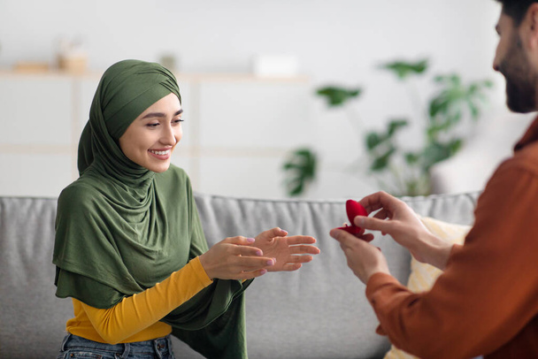 Middle Eastern Boyfriend Proposing To Girlfriend Giving Engagement Ring Indoors - Foto, Imagen