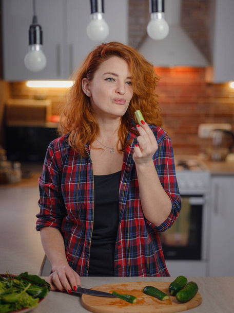 Onnellinen hymyilevä söpö nainen, joka valmistaa tuoretta terveellistä vegaanista kasvissalaattia kotona keittiössä ja kokeilee uutta reseptiä. Ravitsemus laihtumiseen, laihtuminen elintarvikkeiden reseptit käsite - Valokuva, kuva