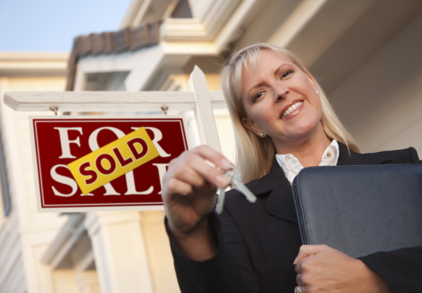 Агент по недвижимости с ключами перед проданным знаком и домом
 - Фото, изображение