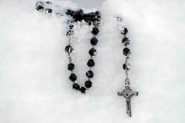 Christian rosary in snow.  Religious symbol.  - Foto, Imagem