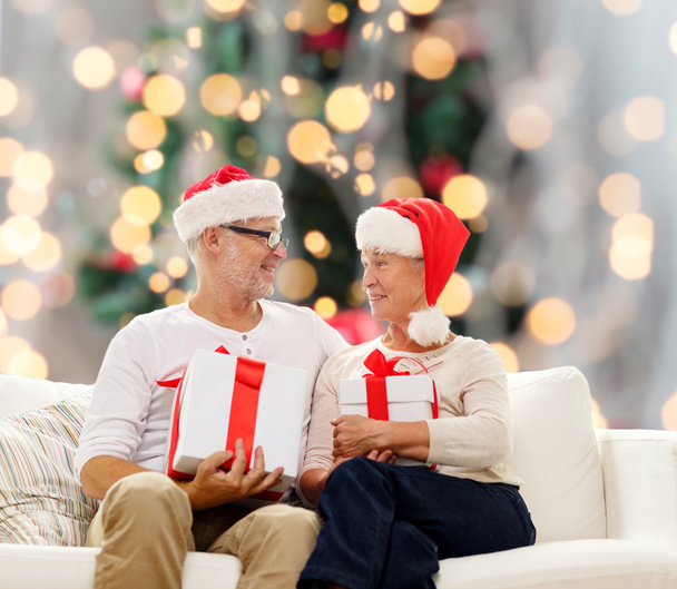 happy senior couple in santa hats with gift boxes - Zdjęcie, obraz
