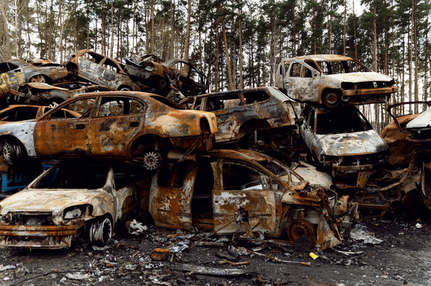 rusty burnt out cars destroyed from rocket explosions. fragments of bombs pierced cars. Russian vandalism in Ukraine. war in Ukraine. destroyed cars in Kyiv, bucha and irpen. - Zdjęcie, obraz