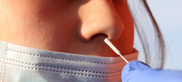 набряк носа і молода школярка під час тесту для діагностики позитиву коронавірусу в школі
 - Фото, зображення
