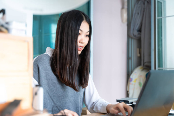 Joven bastante asiático mujer de negocios con portátil en el hogar oficina - Foto, imagen