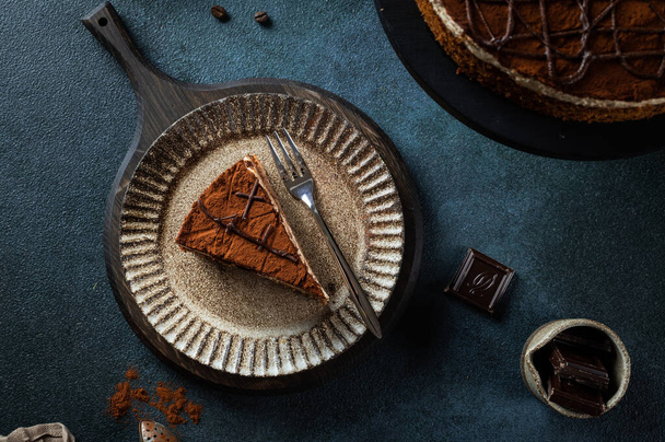 Plate with slice of tasty homemade chocolate cake on blue background. Space for text. Cake flatlay. Piece of chocolate cake. - Foto, Imagen