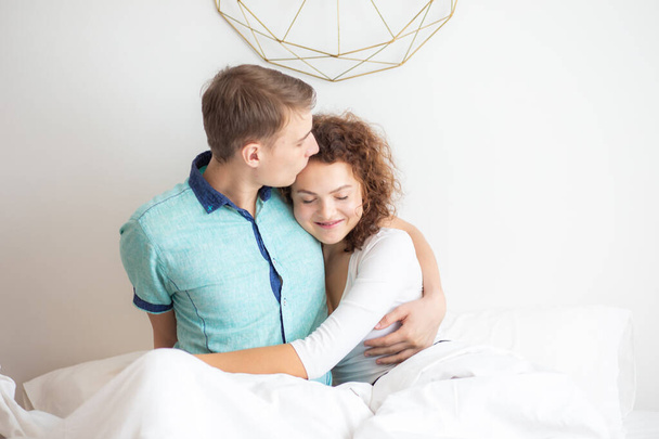 美しいカップルが一緒に寝そべってるのベッドの上で愛するカップルで目を覚ます - 写真・画像