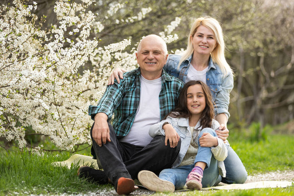 Három generációs család ül kívül tavasszal természet - Fotó, kép