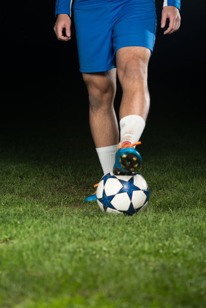 Legs Of Player With Ball On Dark Background - Fotografie, Obrázek