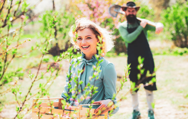 Pretty woman working and playing in beautiful garden. Beautiful woman on Background with flowers on a spring day. Woman planting flowers. - Foto, Bild