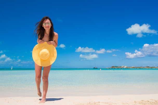 Молодая женщина в шляпе на пляже наслаждается отдыхом на Карибах
 - Фото, изображение